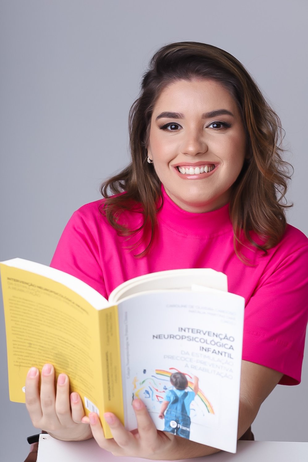 Bruna Ribeiro estudando um livro sobre intervenção neuropsicológica infantil