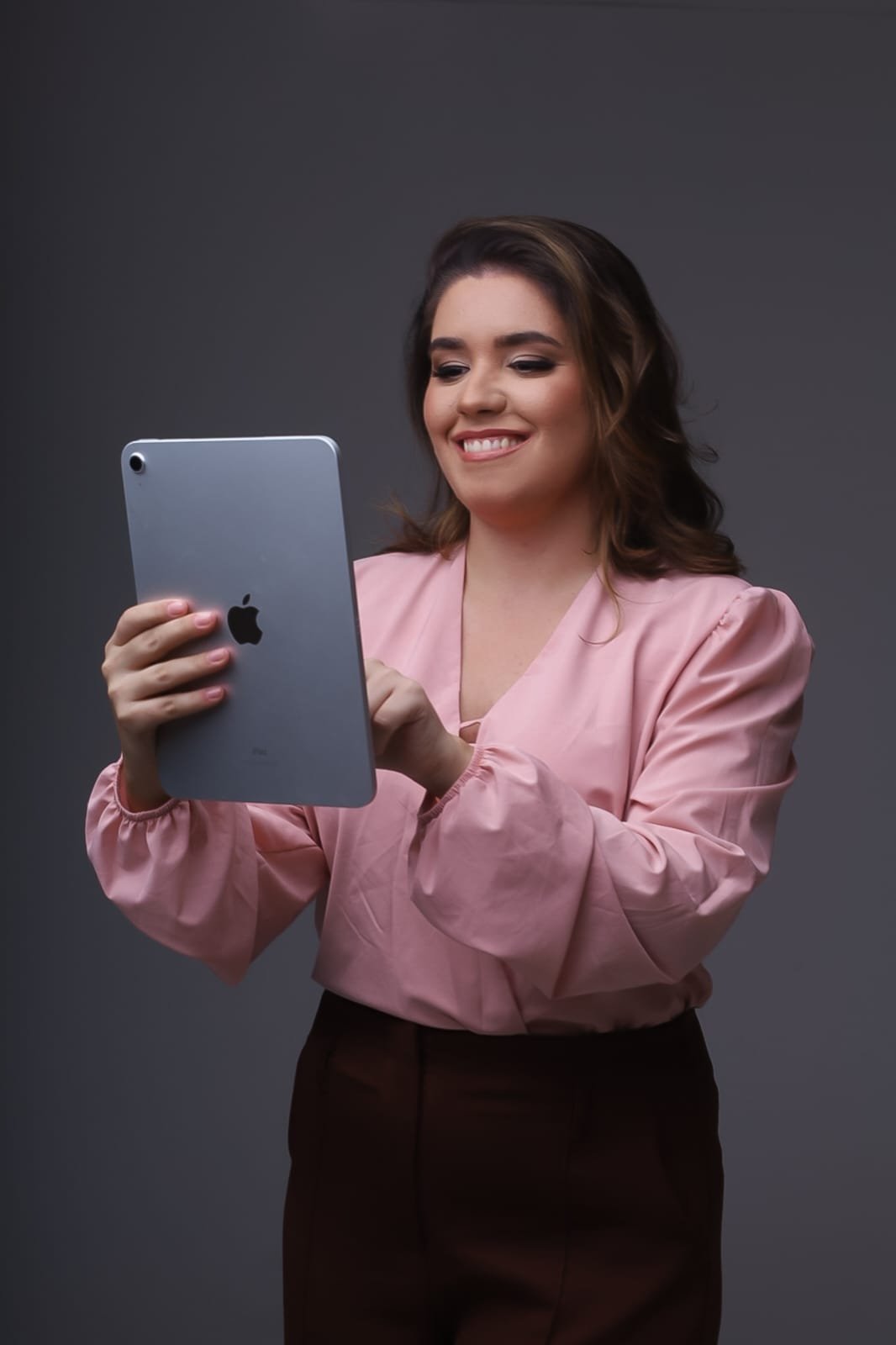 Bruna Ribeiro em atendimento online, segurando um tablet